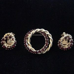 Vintage entwined gold tone brooch and earrings with deep red rhinestones.